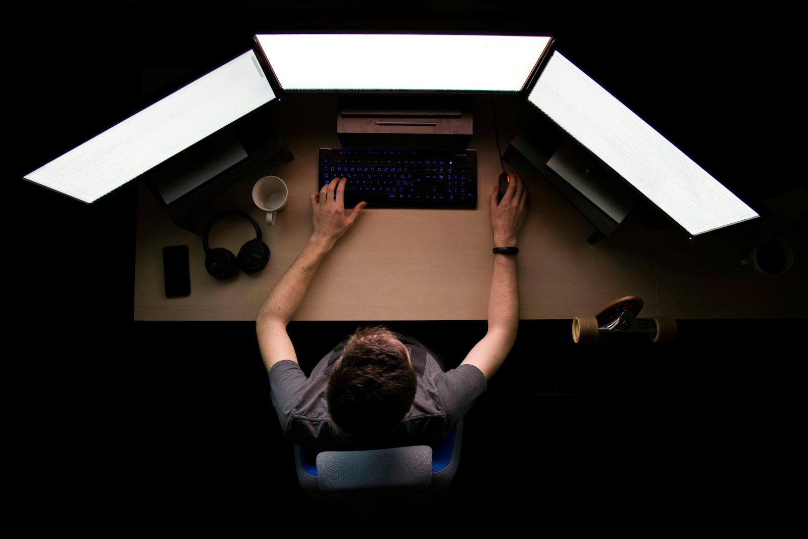 Analyst at a dark desk lit by a monitor